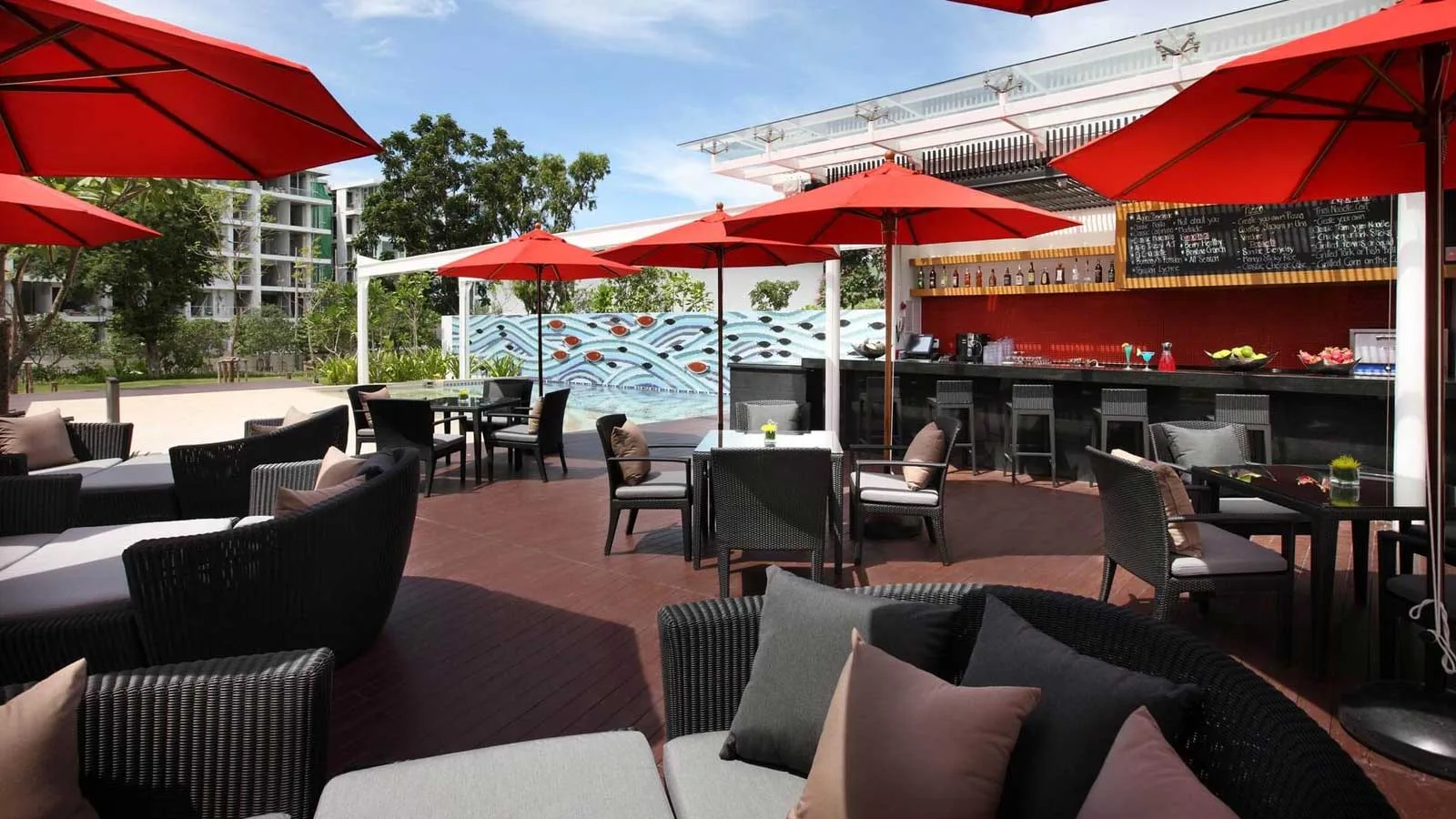 Aqua Pool Bar terrace with lounge seating and red parasols at Amari Hua Hin