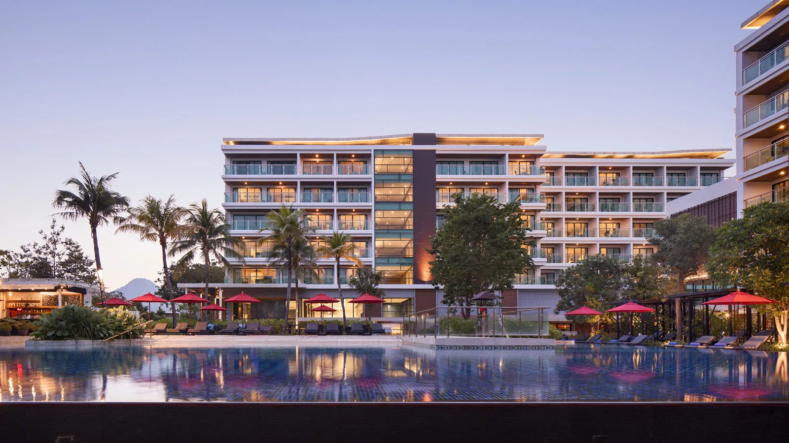 Amari Hua Hin pool and buildings lit up in the evening