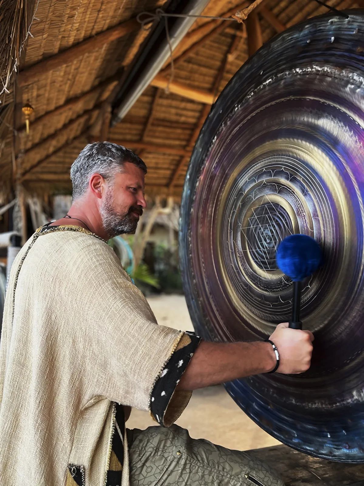 Sound healer playing a large gong at AUM Phangan
