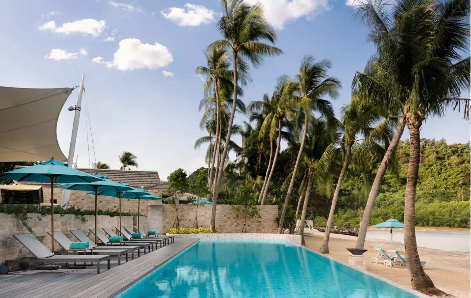 Palm-lined pool and loungers at Avani+ Samui beside the beach on the Taling Ngam coast