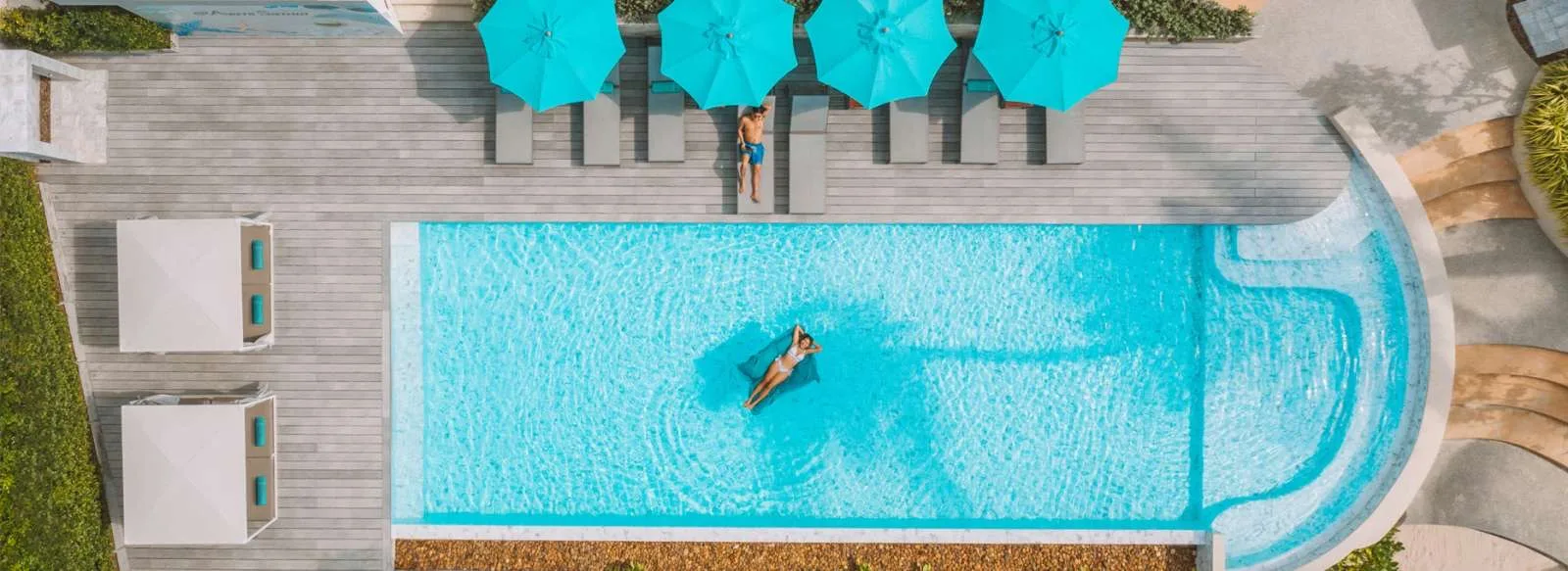 Aerial view of the Avani+ Samui pool with turquoise umbrellas, used by day pass visitors