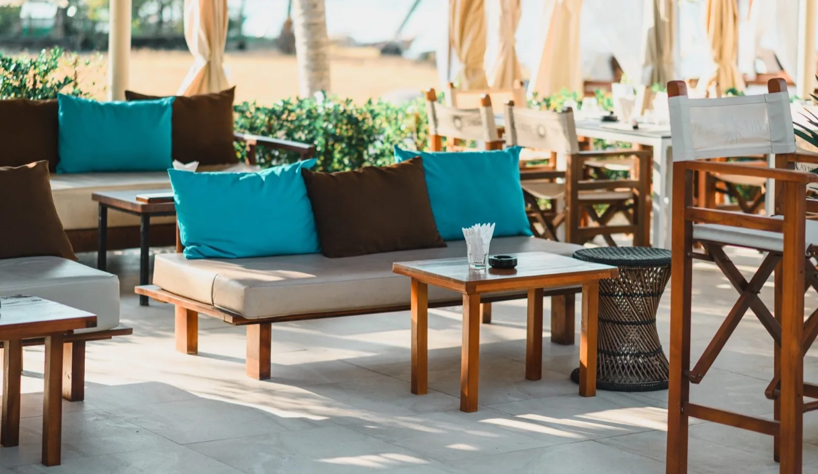 Pool deck sofa lounge seating with teal cushions at Carpe Diem Beach Club Phuket