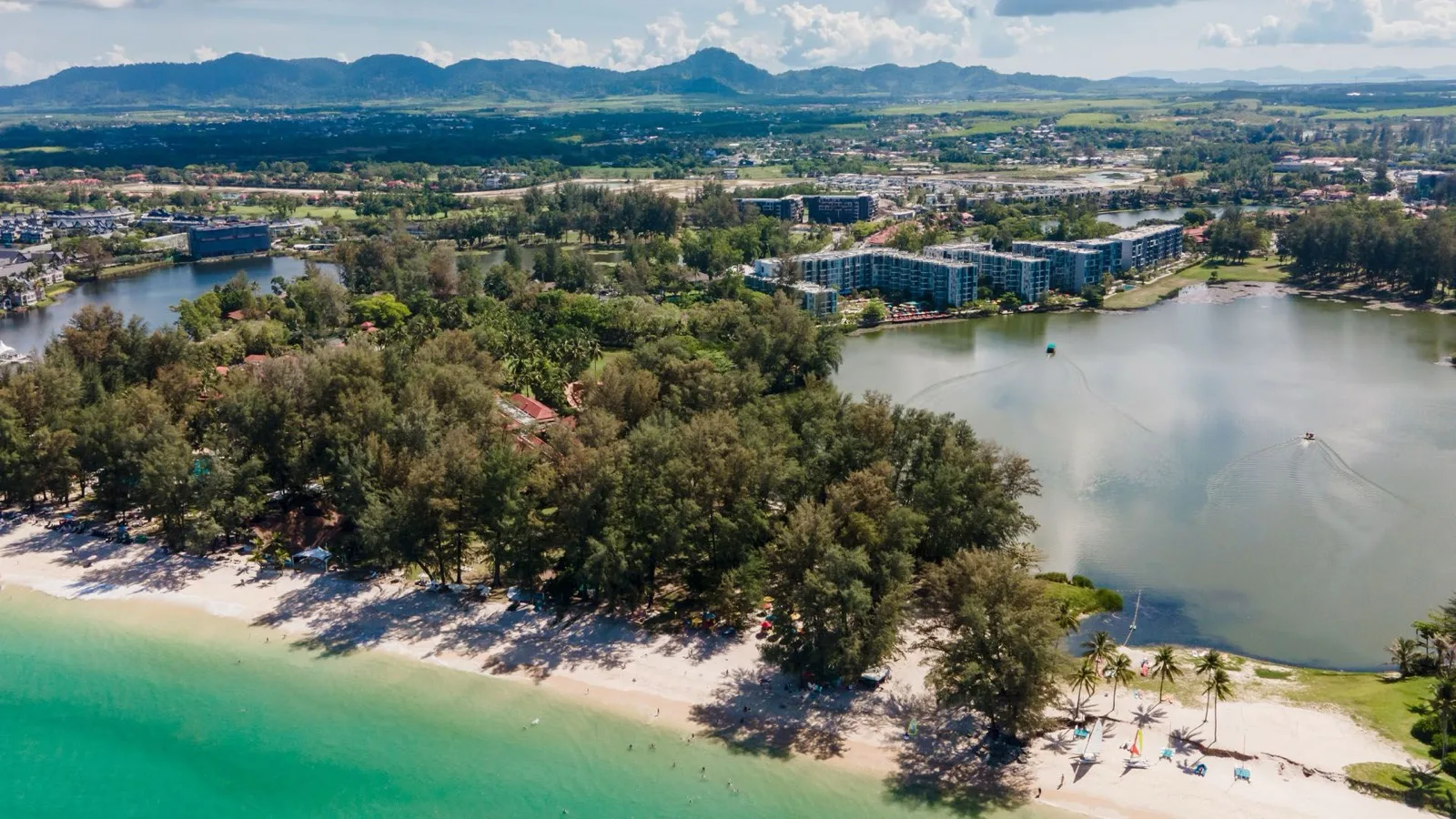 Aerial view of Cassia Beach on Bang Tao with the Laguna lagoons and Cassia Phuket buildings behind