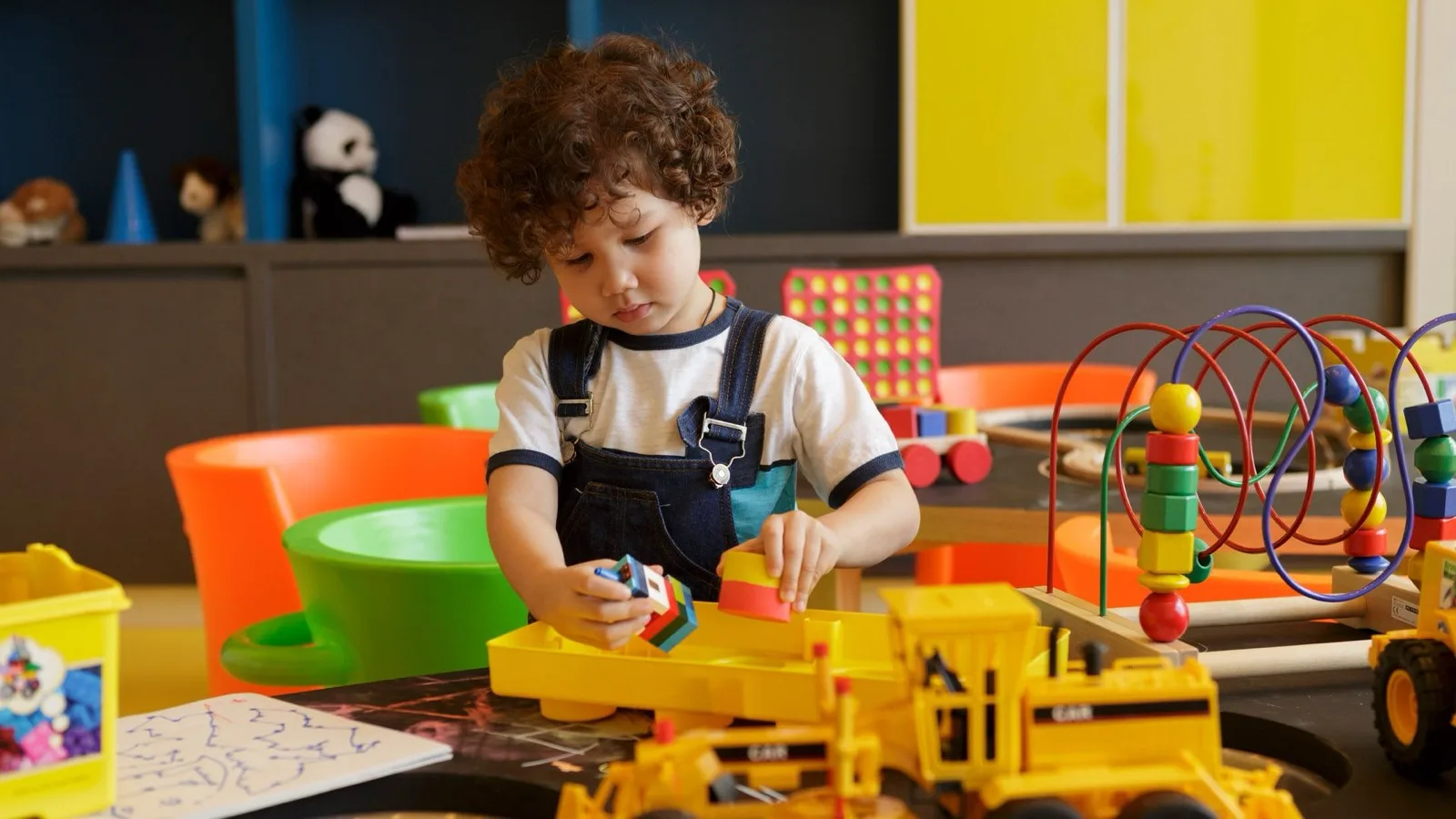 Child playing with toys in the Play Play kids' club at Cassia Phuket