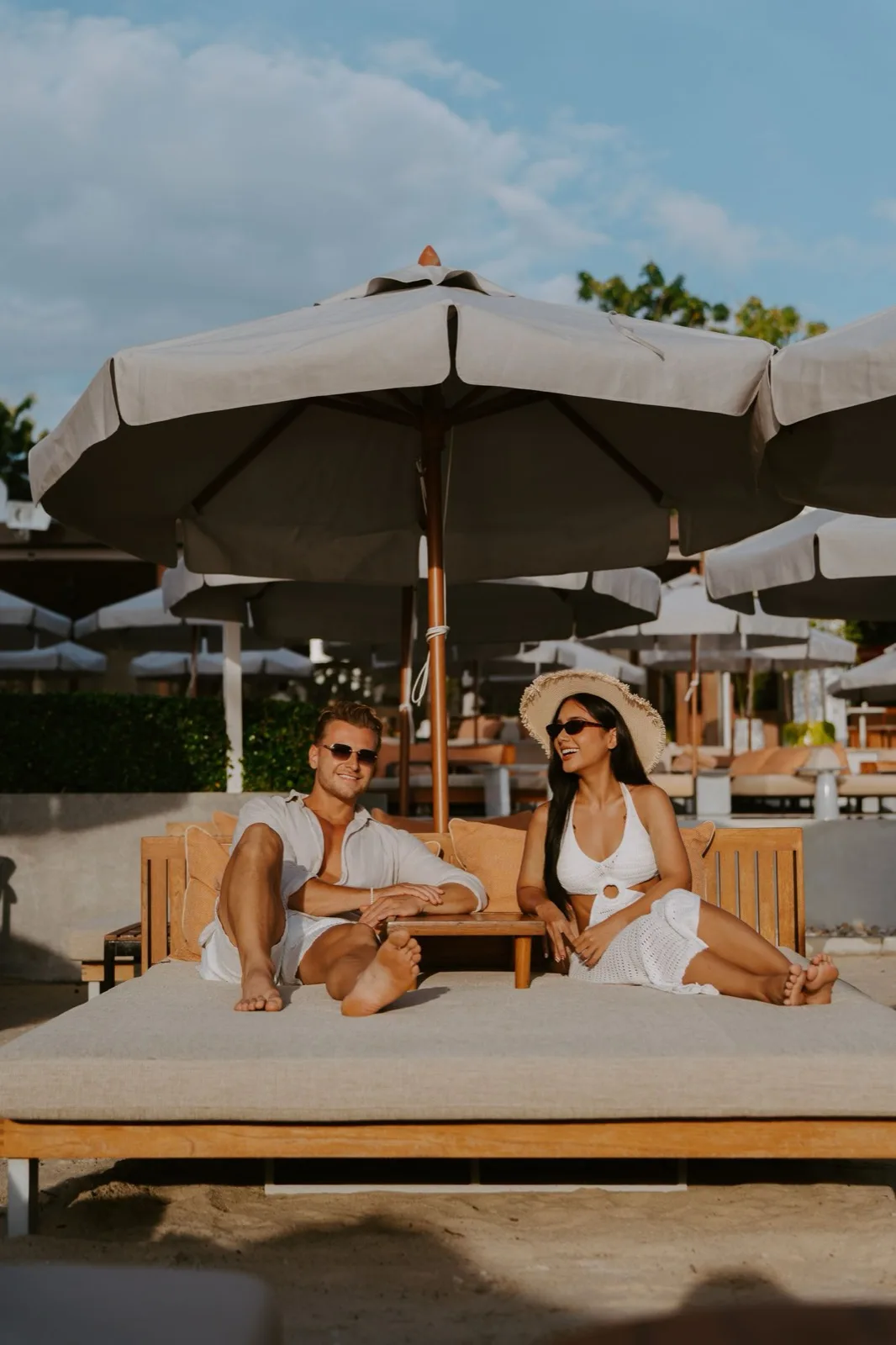 Couple relaxing on a shaded daybed at CLUB SEEN Koh Samui on Chaweng Beach