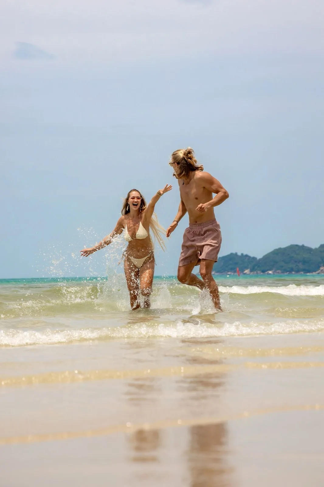 Two guests running into the sea in front of CLUB SEEN Koh Samui on Chaweng Beach