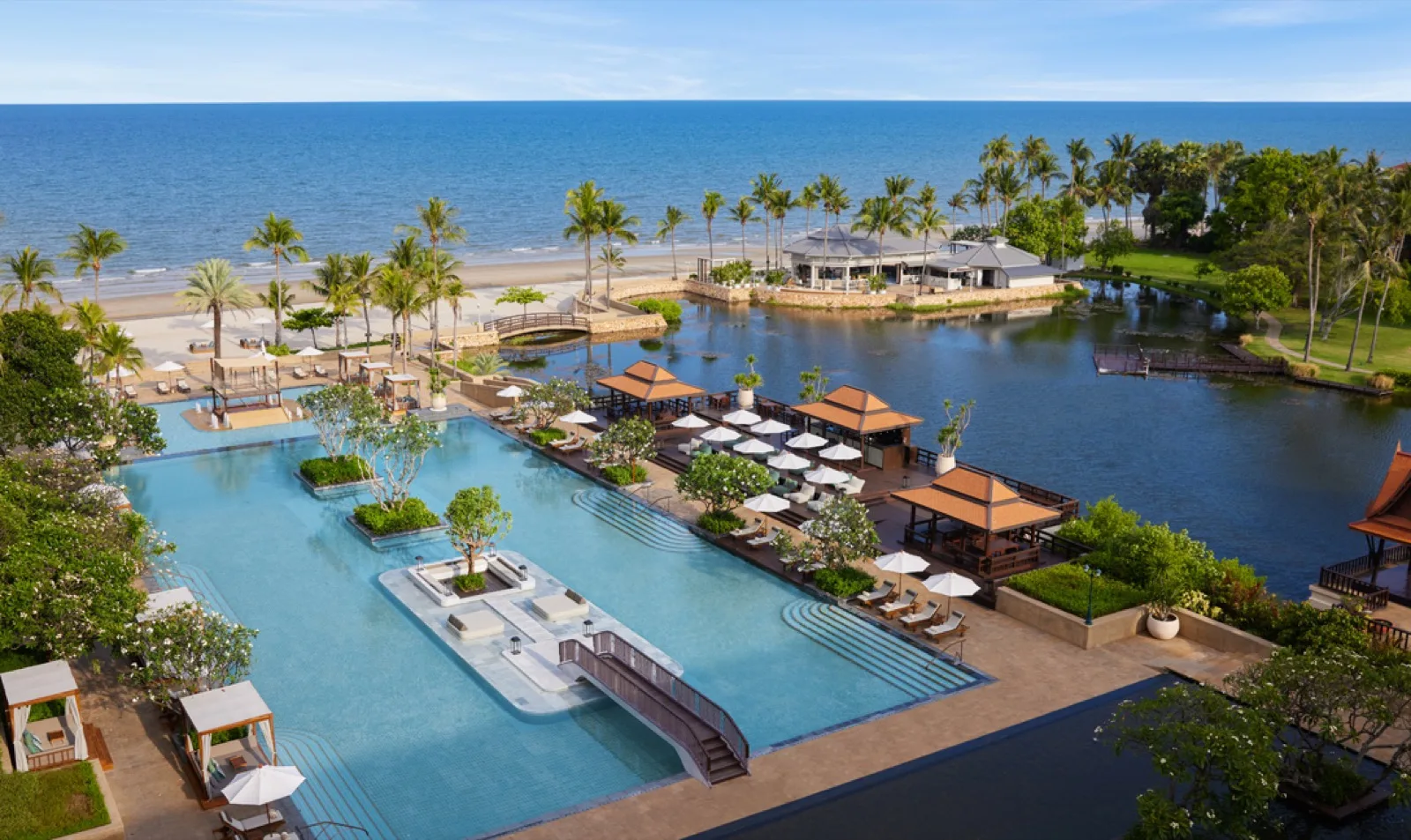 Aerial view of the lagoon pool, gardens and beachfront at Dusit Thani Hua Hin