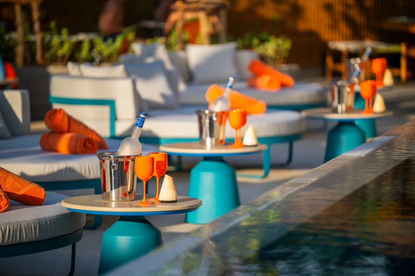 Poolside day beds with orange towels and ice buckets at Endless Summer Beach Club Patong