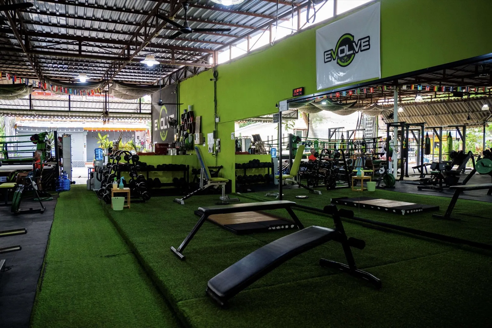 Outdoor gym hall with artificial turf, benches and machines at Evolve Health Club, Srithanu