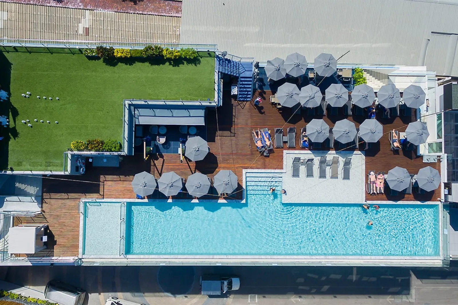 Aerial view of the Hotel Clover Patong rooftop pool with sun loungers and parasols on Level 5