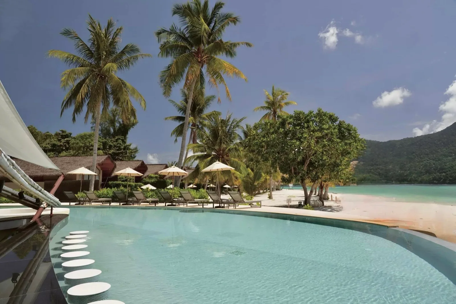 Infinity edge pool with stepping stones and palm trees facing Sunrise Beach at Irene Resort Koh Lipe