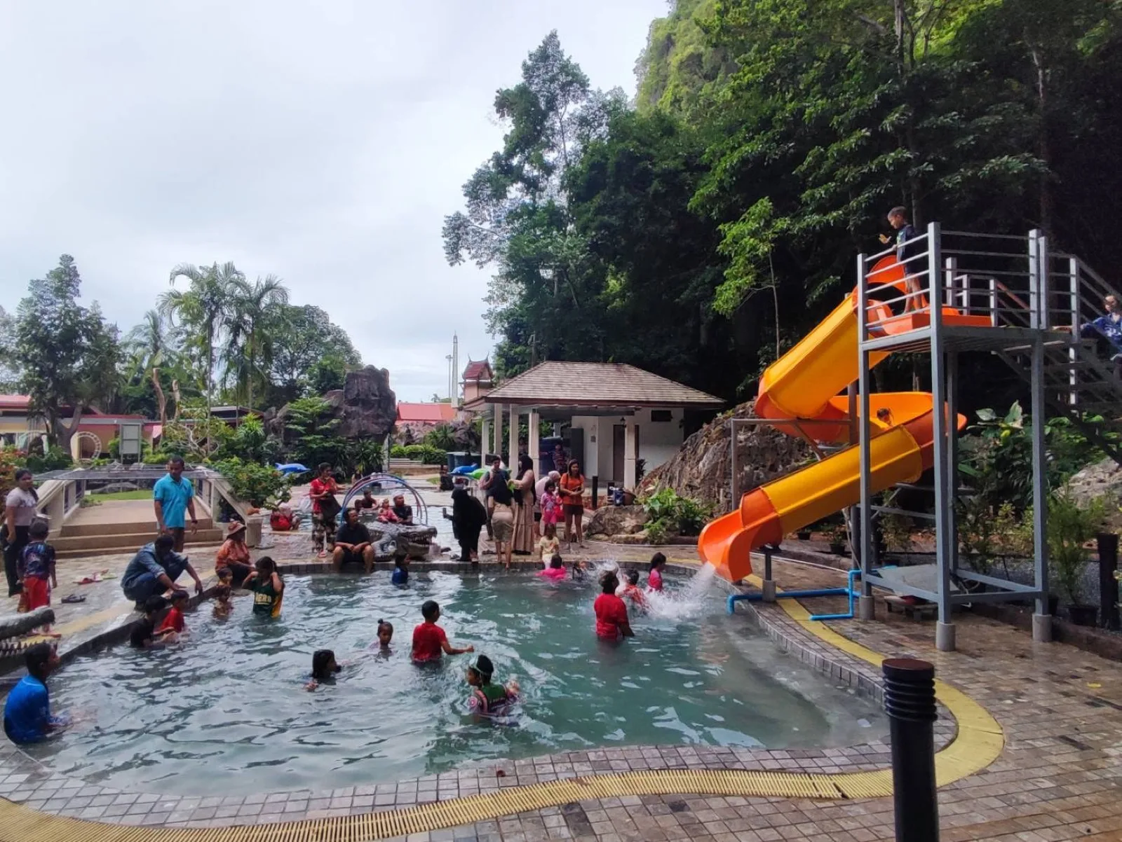 Family pool with a yellow water slide at Khao Chaison Hot Spring