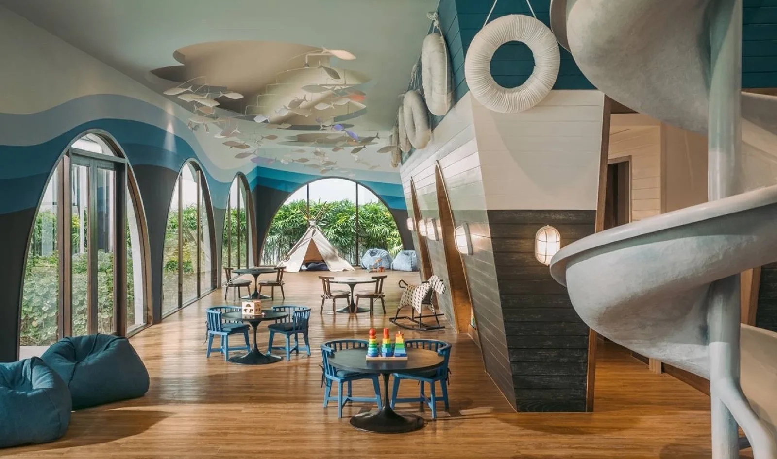 Bright JUNIO Kids' Club playroom with slide at Kimpton Kitalay Samui