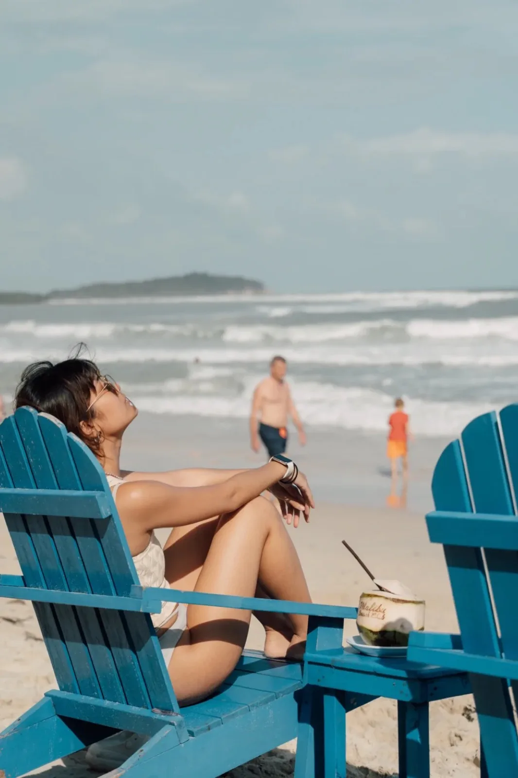 Guest relaxing in a blue beach chair on Chaweng Beach at Malibu Beach Resort Samui