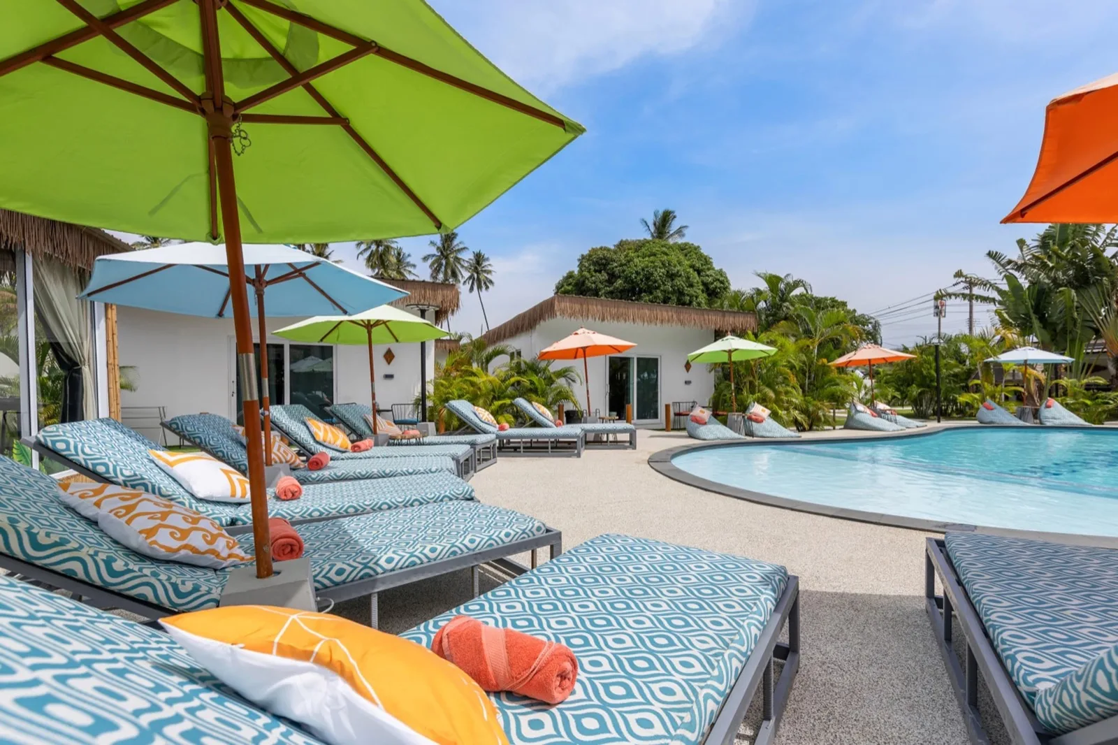 Sun loungers with patterned cushions beside the pool at Maya Resort Samui in Bophut
