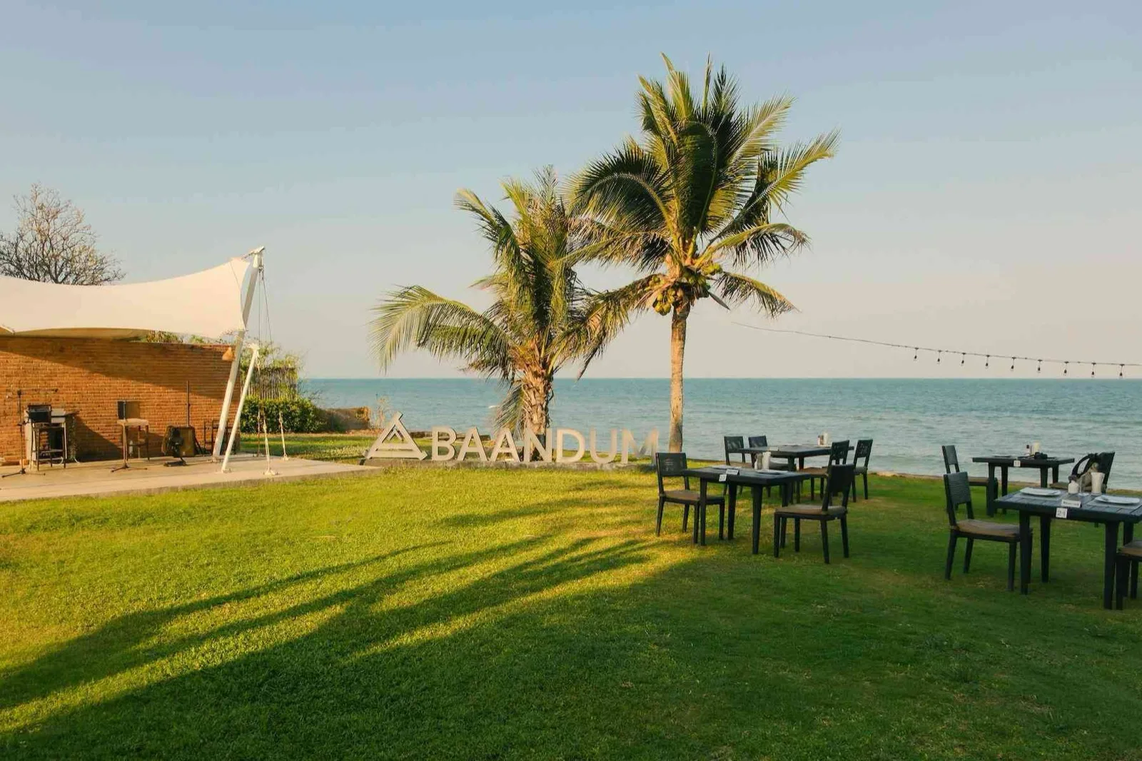 Baan Dum restaurant lawn with tables facing the Gulf of Thailand at Mövenpick Asara Hua Hin