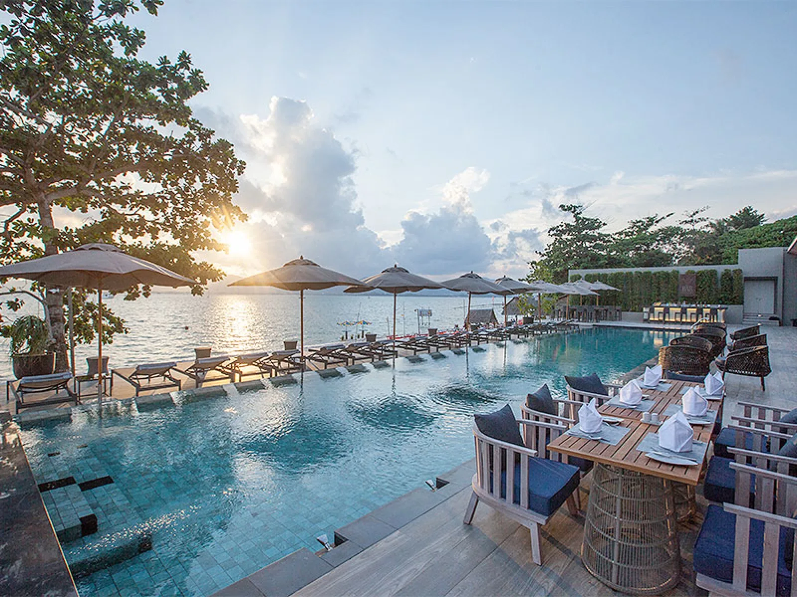 Sunset over the beachfront infinity pool and dining terrace at My Beach Resort Phuket