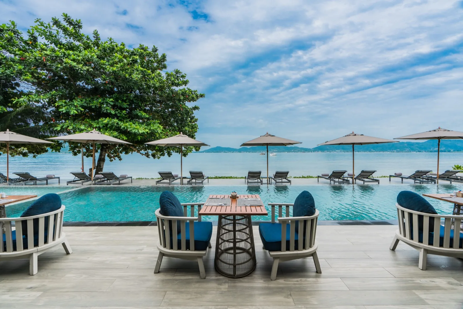 Poolside tables at My Cafe overlooking the infinity pool and sea at My Beach Resort Phuket