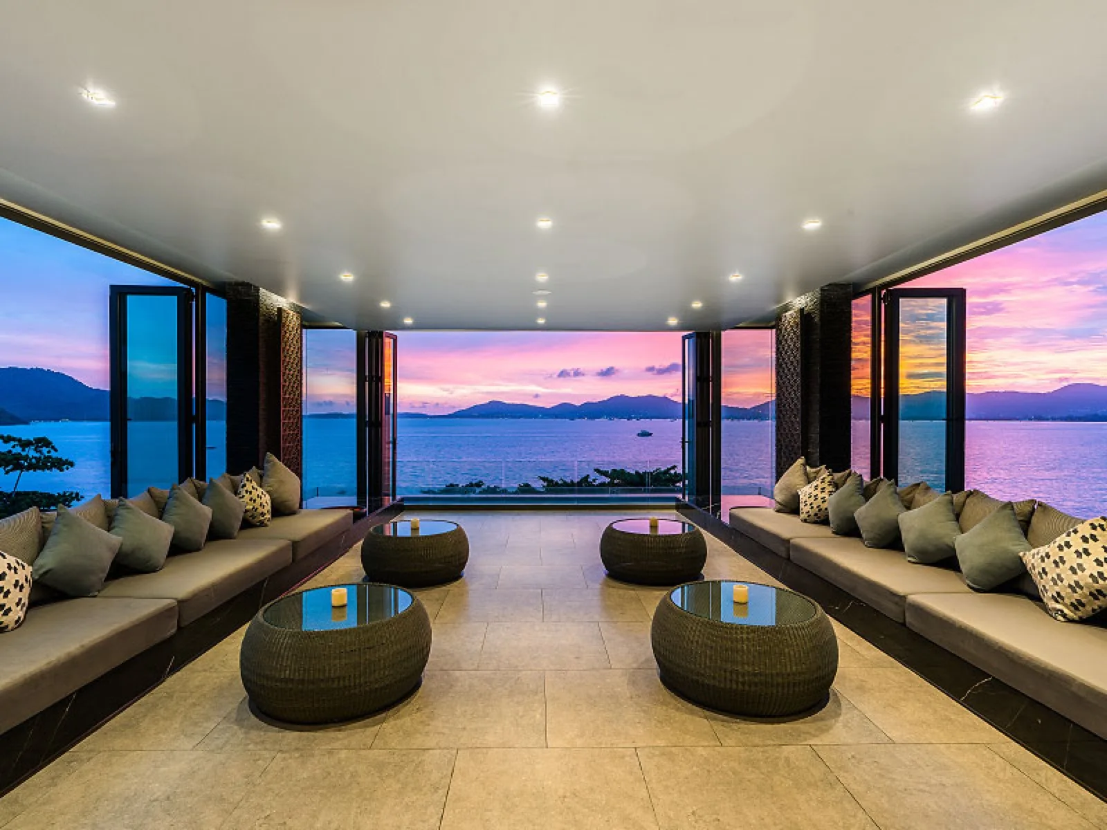 Open lobby lounge at My Beach Resort Phuket with a panoramic sunset over the bay