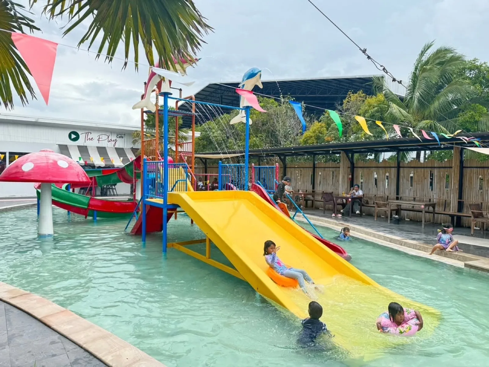 Climbing frame and yellow slide in the shallow pool at The Play Waterpark, Nakhon Si Thammarat