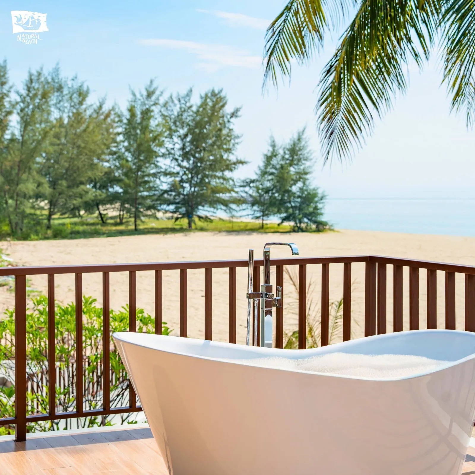 Outdoor bathtub on a sea-facing villa balcony at Natural Beach Resort