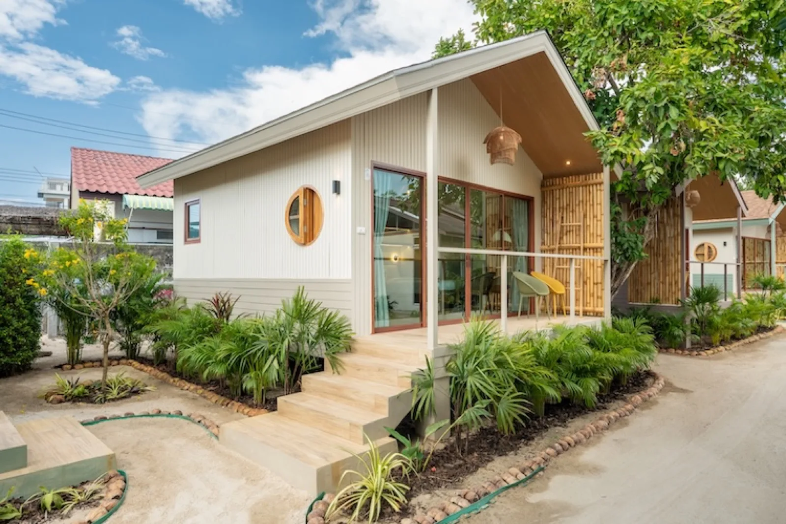 Row of guest bungalows along a garden path at Orion Healing Centre in Srithanu