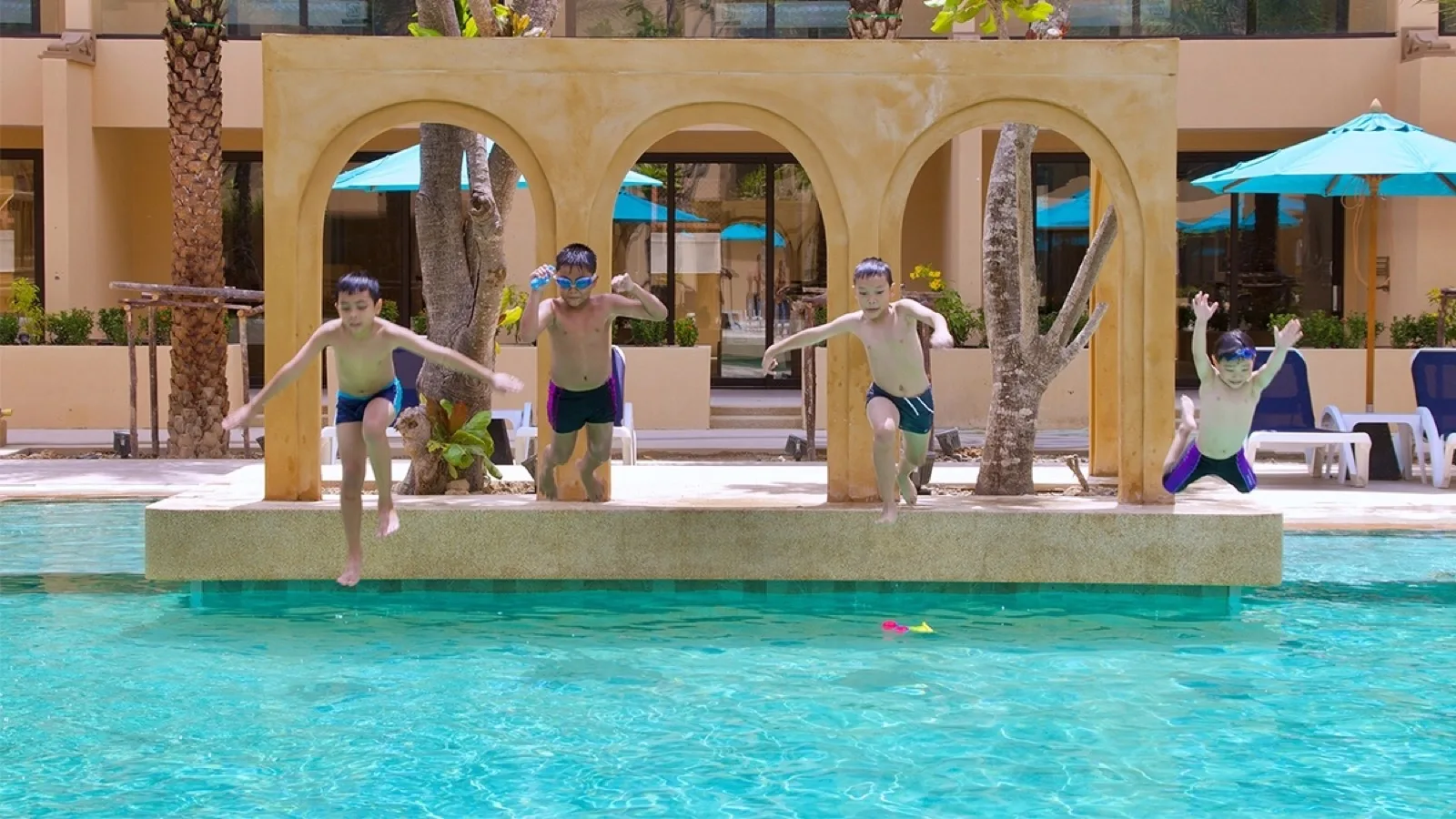 Children jumping into the themed pool at Pamookkoo Resort Phuket