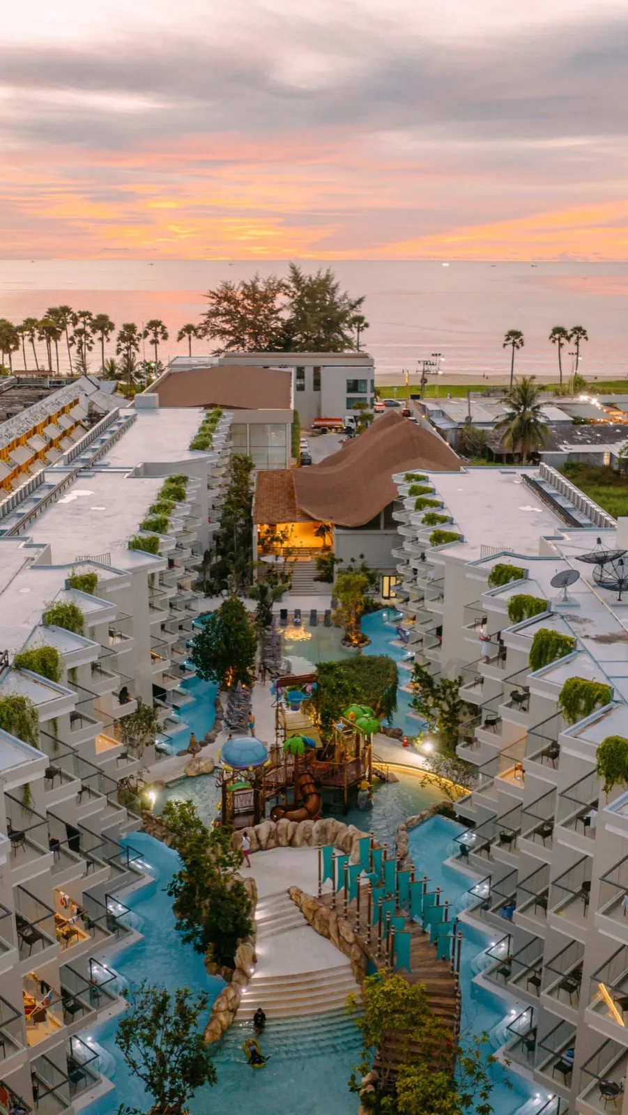 Aerial view of the pools and resort buildings at Phuket Emerald Beach Resort at dusk
