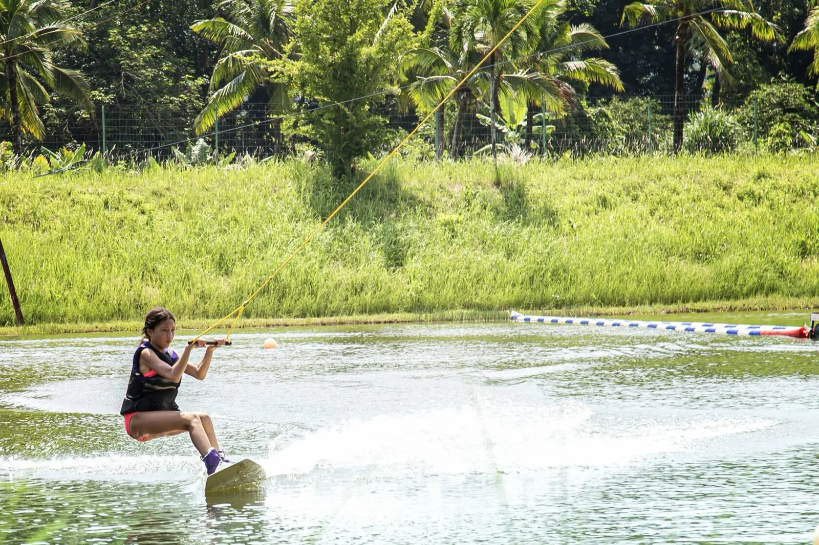 Wakeboarder carving across the cable lake at Phuket Wake Park