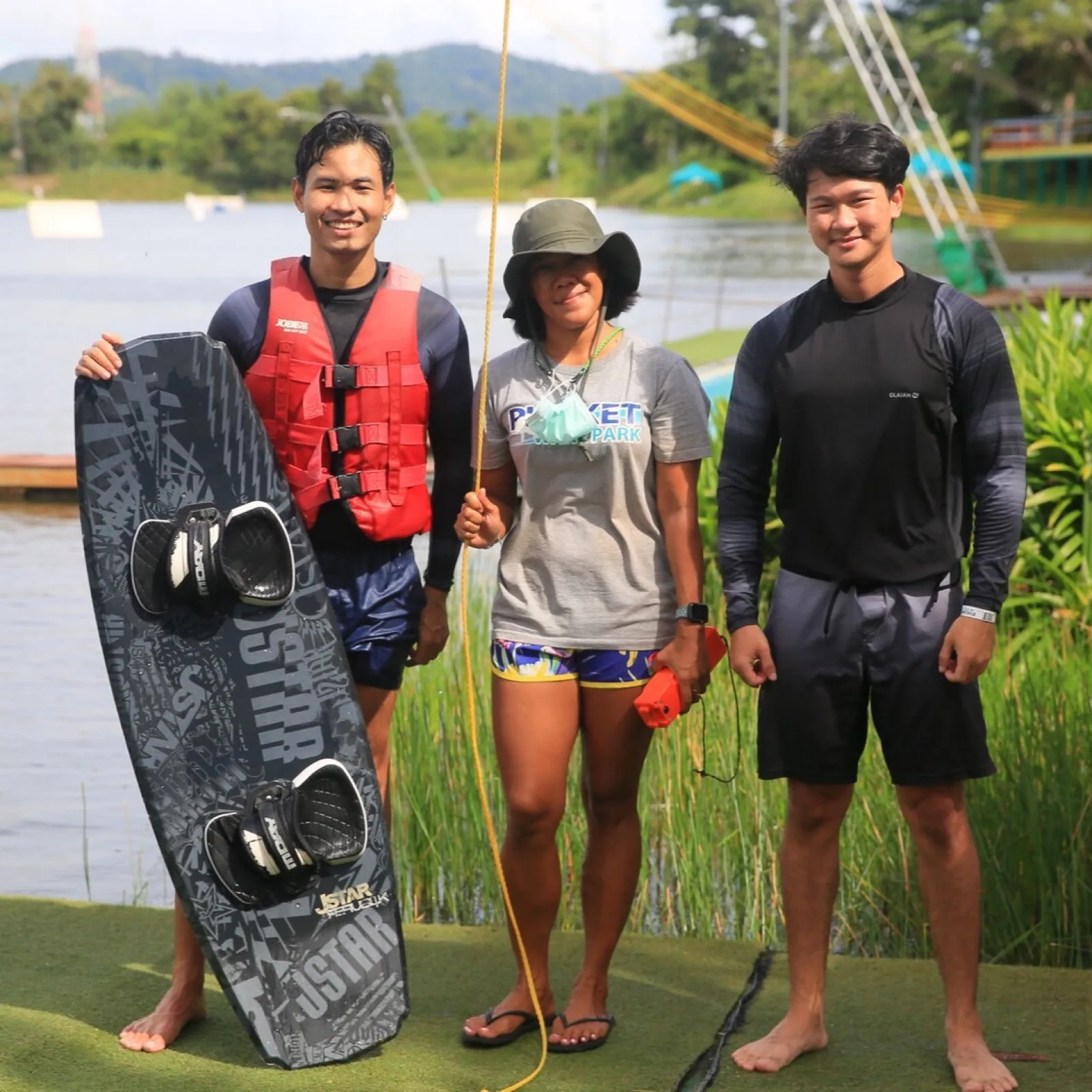 Phuket Wake Park coaches and a rider with a wakeboard beside the lake