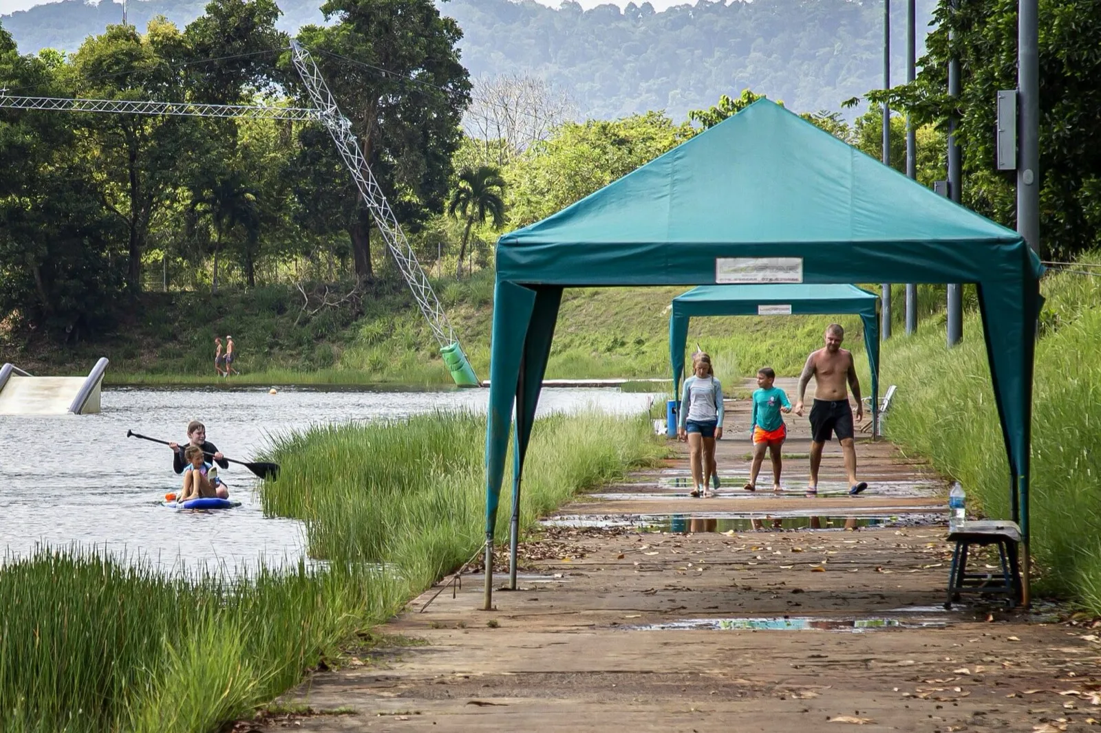 Lakeside path and shaded rest area at Phuket Wake Park with a rider on the water