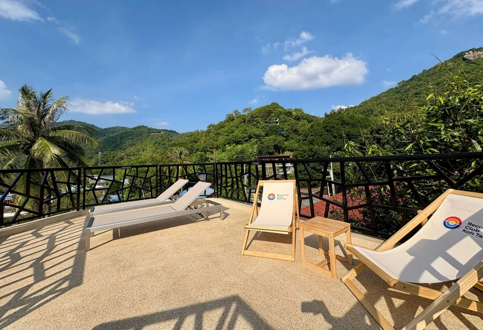 Rooftop sun loungers and deck chairs overlooking the green hills of Koh Tao at Recovery Club