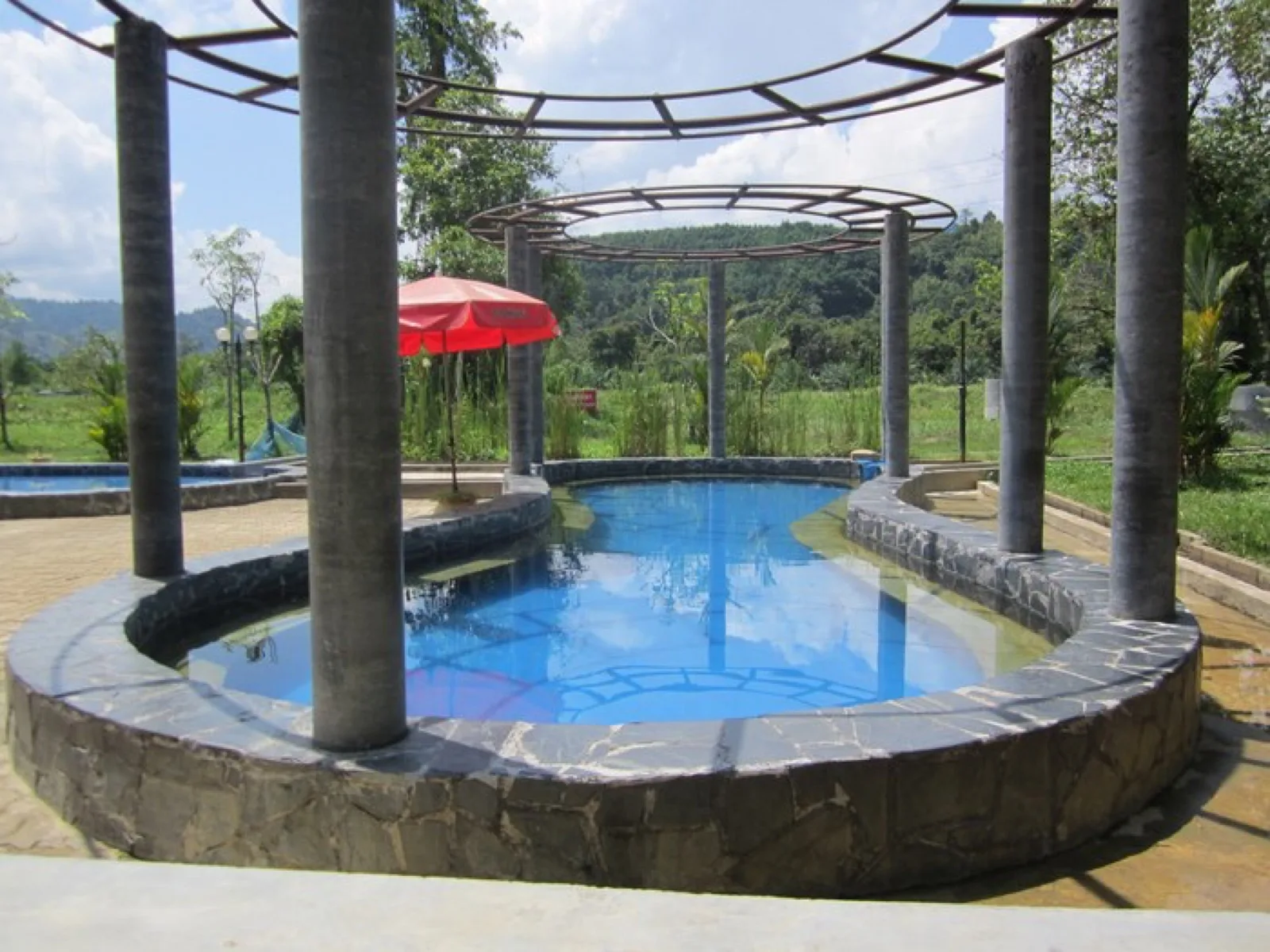 Round hot spring pool beneath a pergola at Rommanee Hot Spring