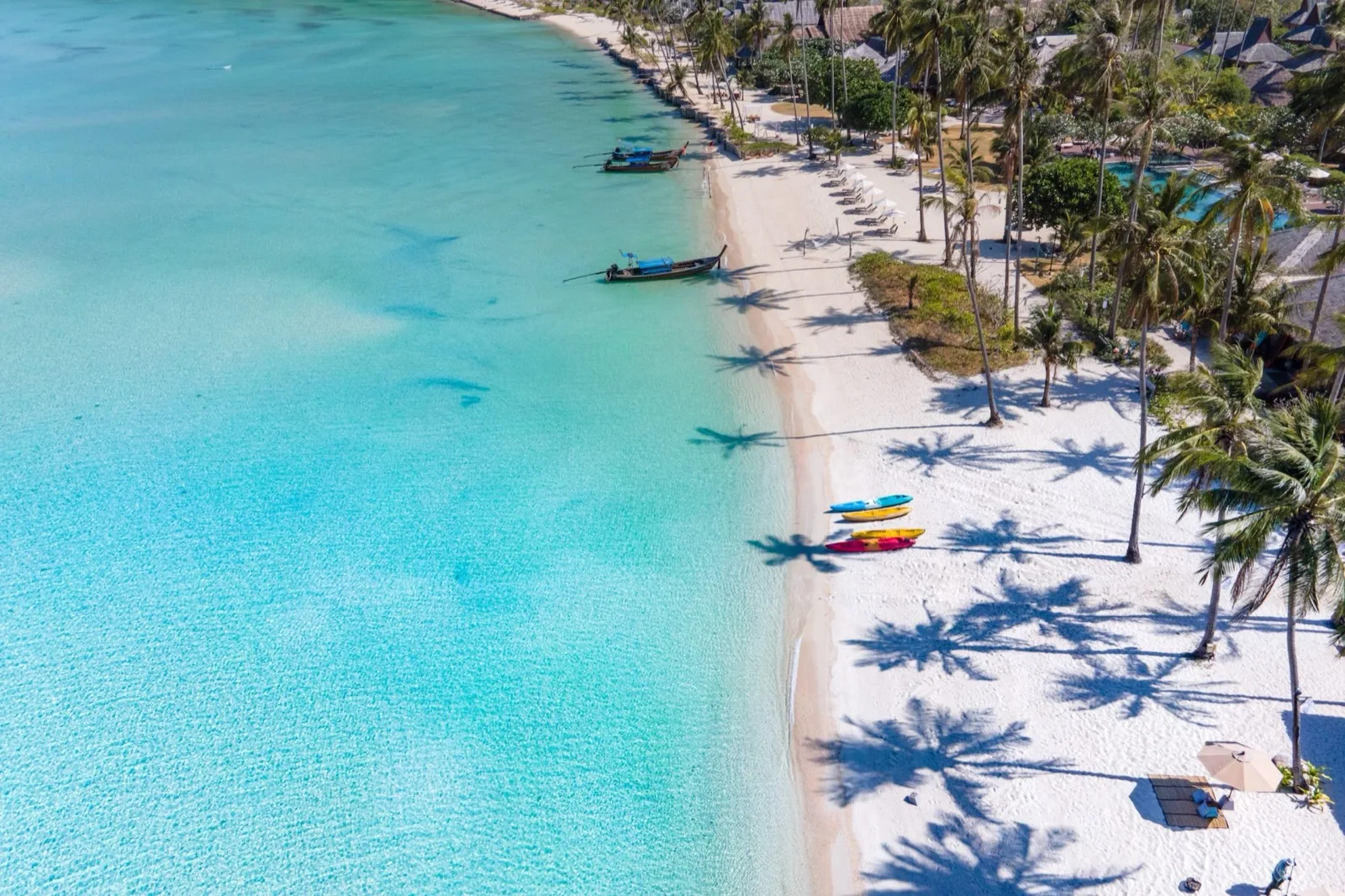 Aerial view of the white-sand beach, palms and turquoise water at SAii Phi Phi Island Village in Loh Ba Gao Bay