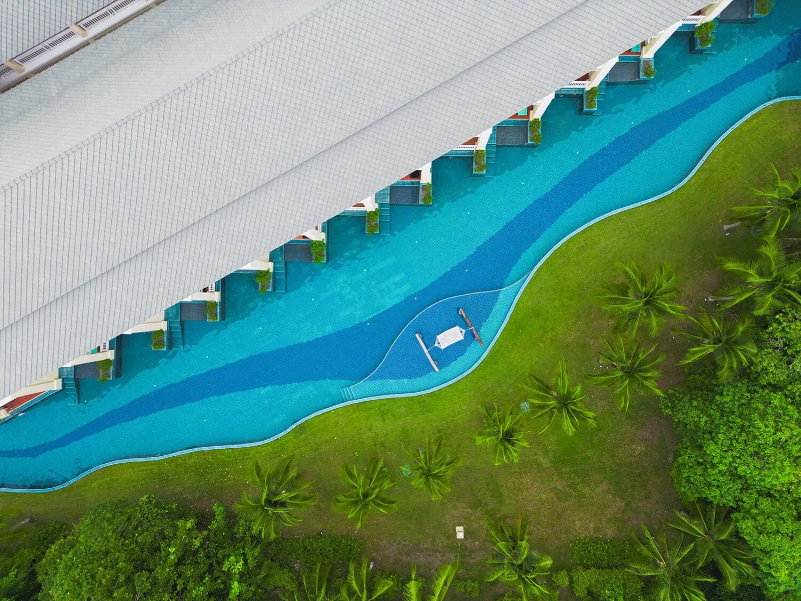 Aerial view of the winding lagoon pool alongside the accommodation wing at Sofitel Krabi