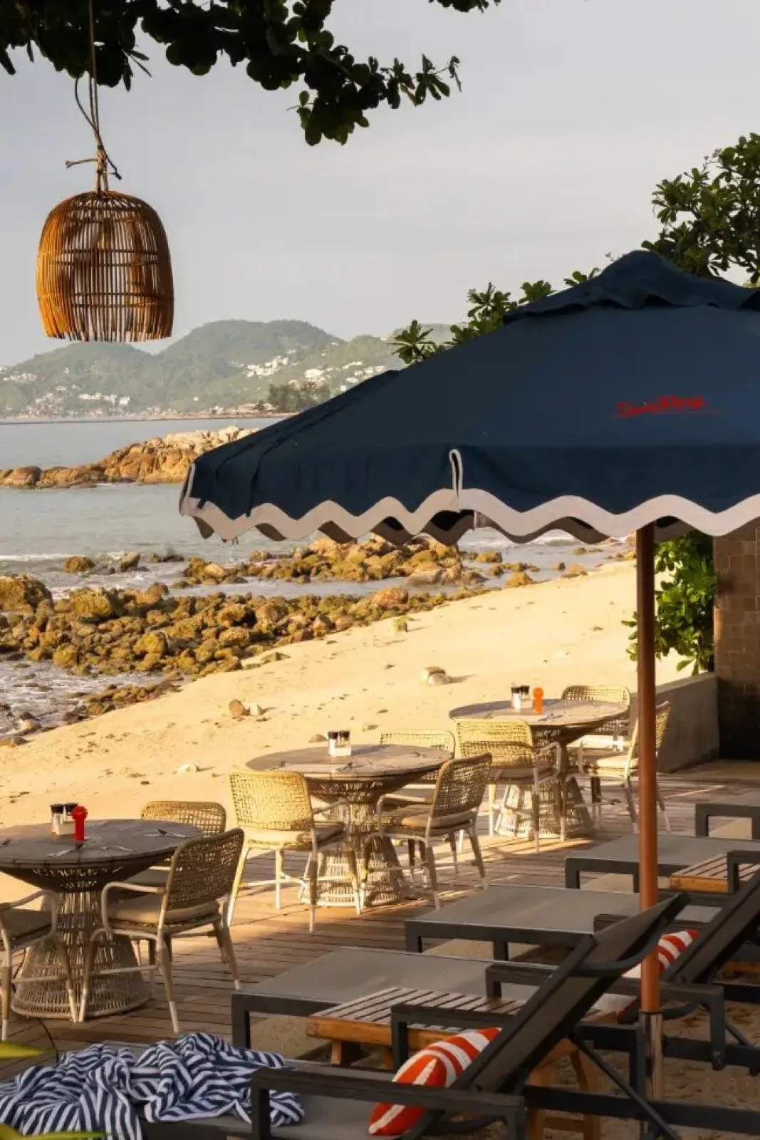 Shaded beachfront tables overlooking the bay at SunRay Social & Swim Club Koh Samui