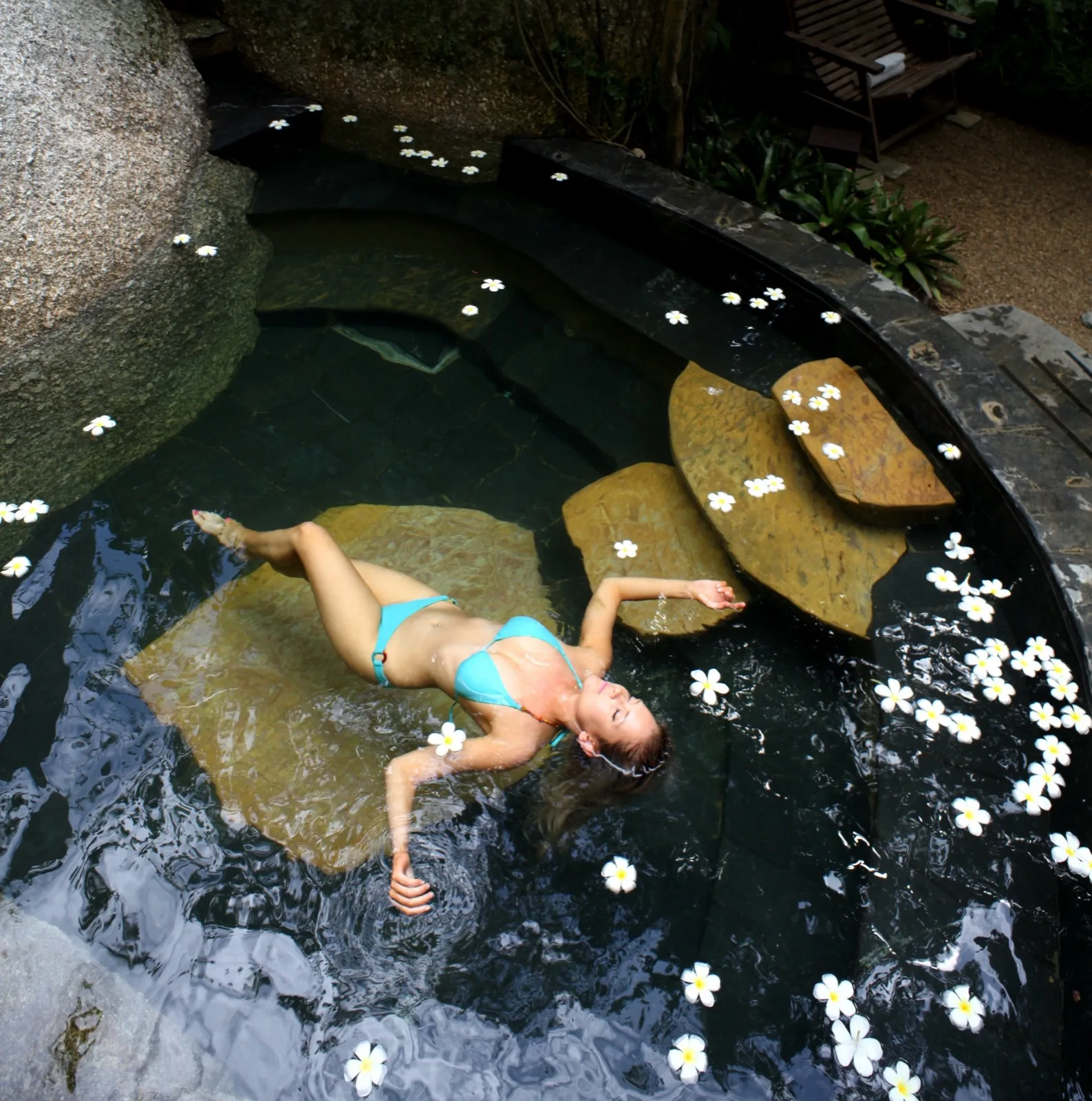 Guest floating in a rock plunge pool at Tamarind Springs Steam and Dream