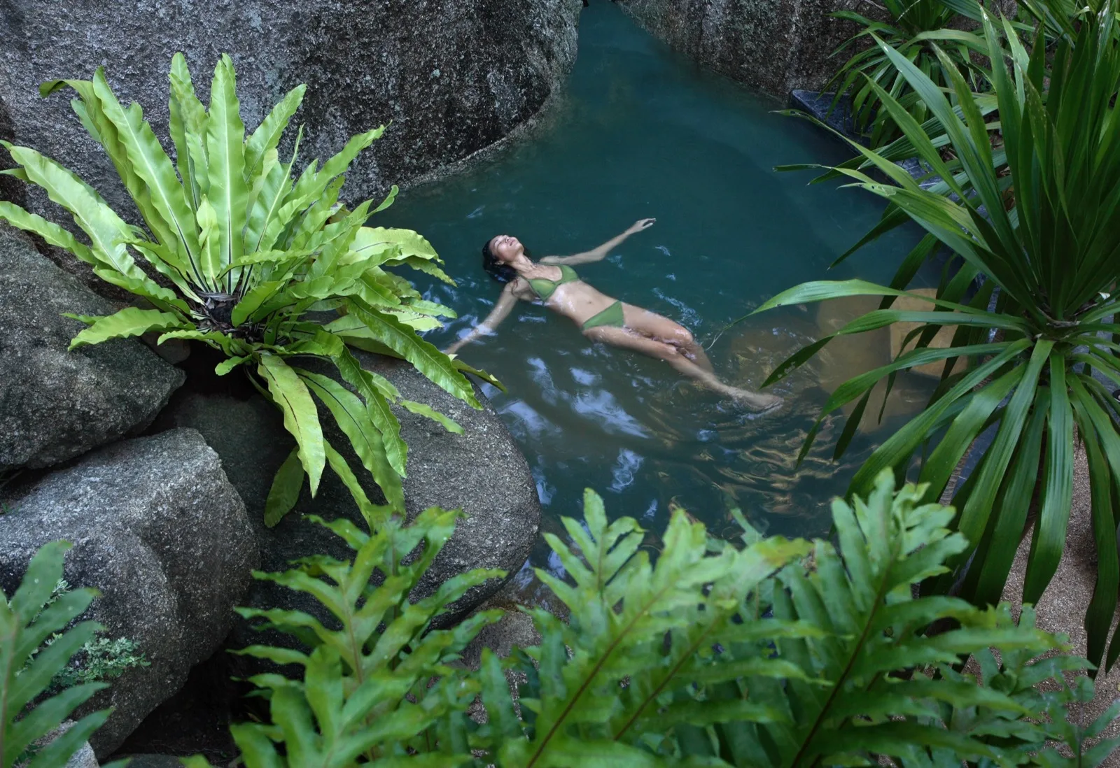 Guest swimming in a forest plunge pool at Tamarind Springs, Koh Samui