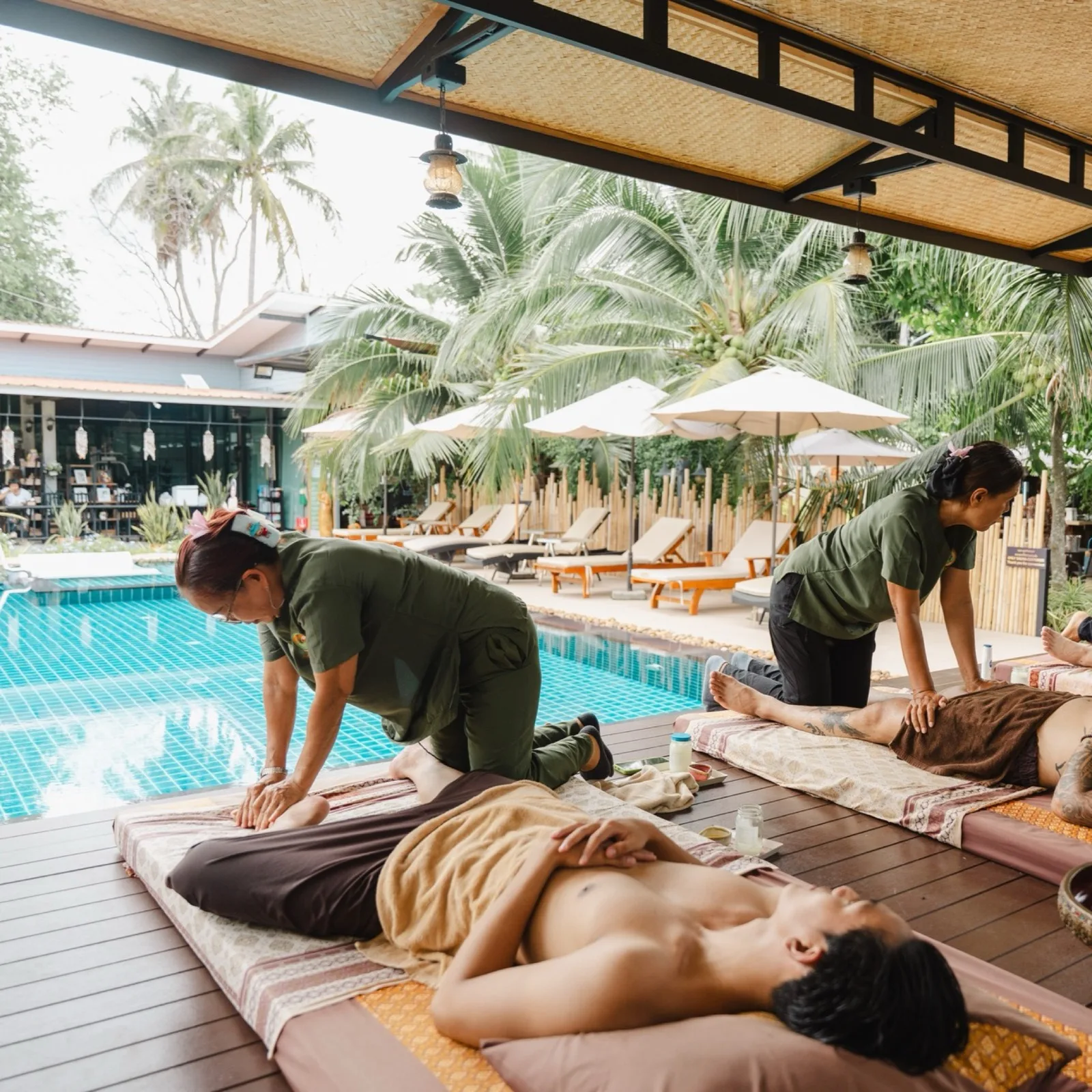 Therapists giving Thai massages by the pool at The Cottage Retreat Hua Hin