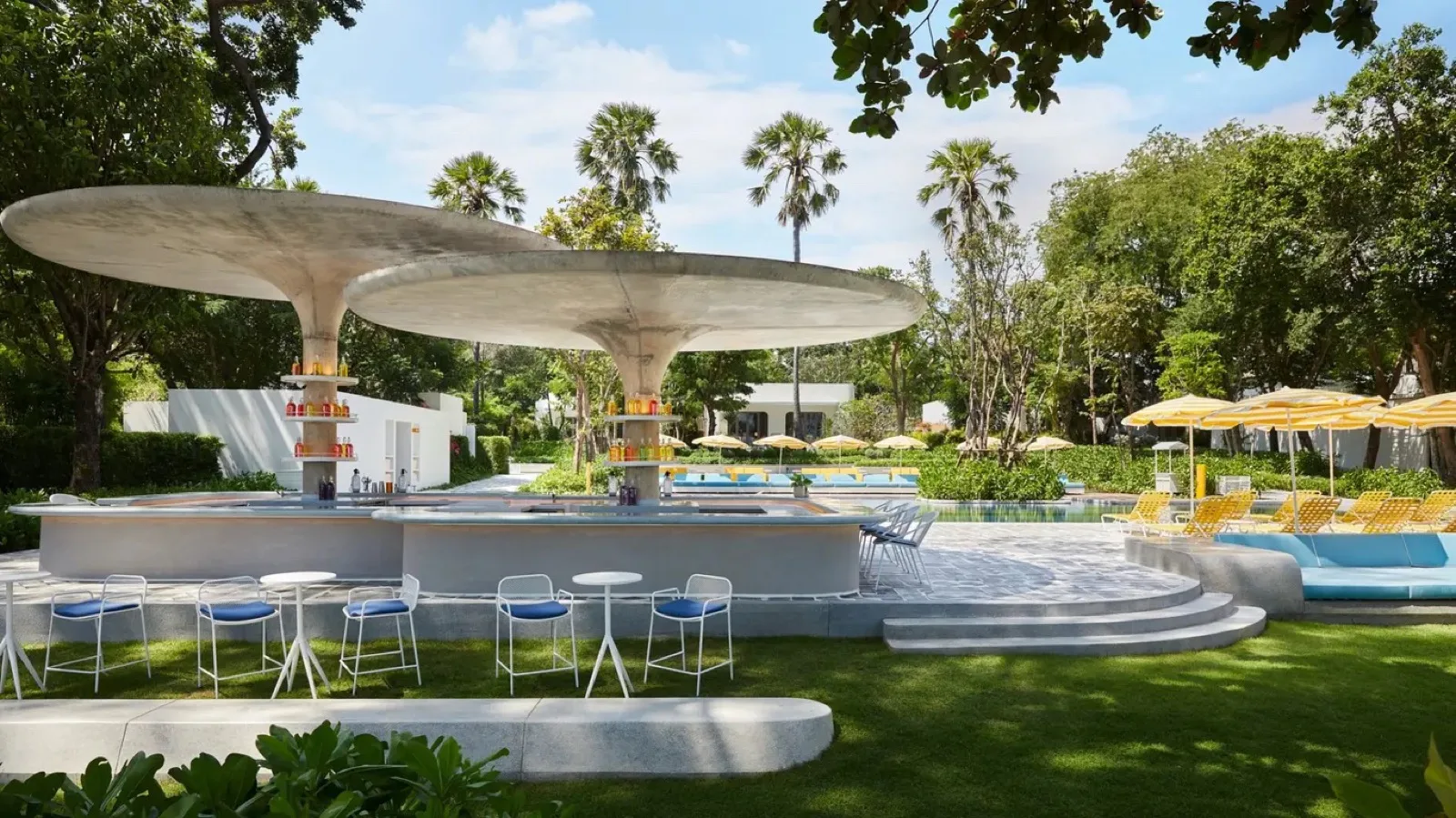Lido Pool Bar with its mushroom-shaped canopies and garden lawn at The Standard Hua Hin