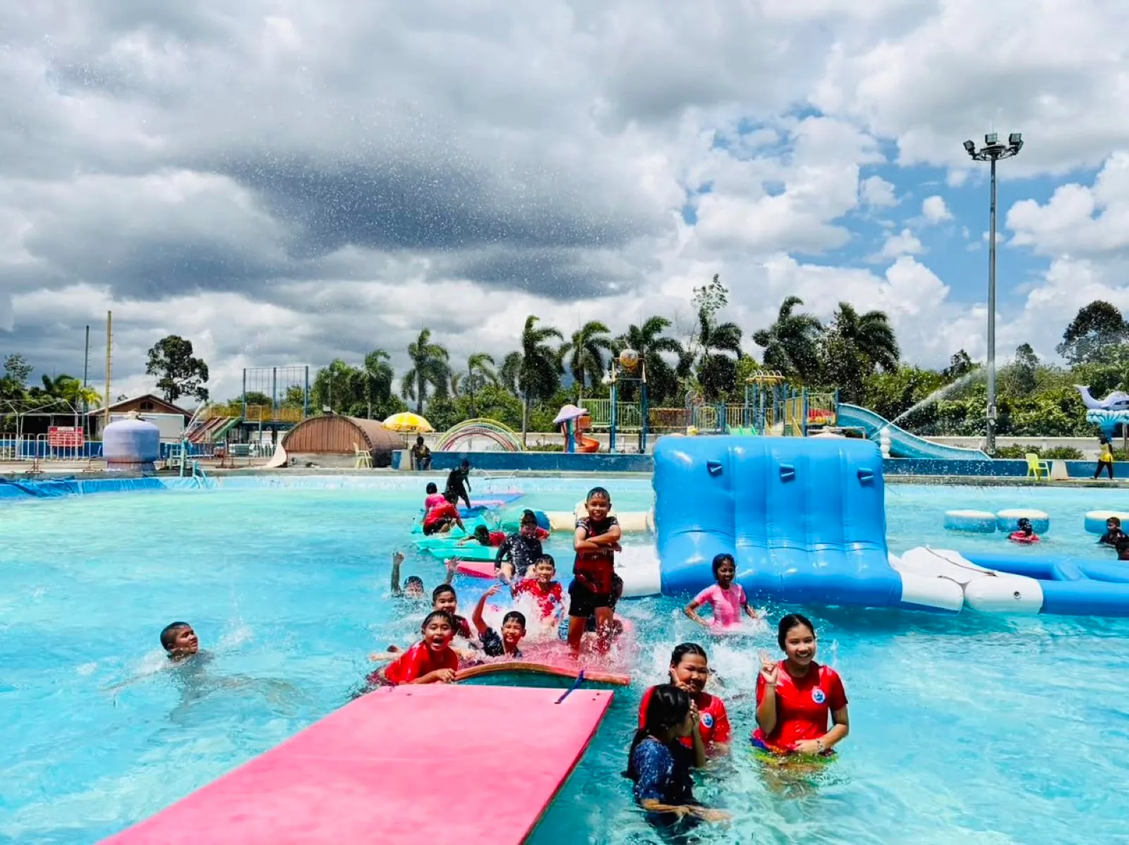 Families on the inflatable obstacle course in the main pool, Thung Song Water Park