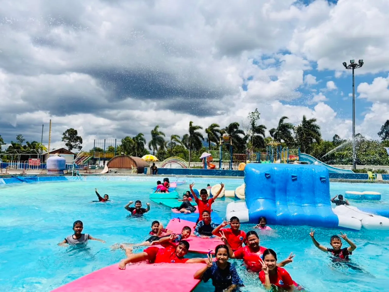 School group playing on the floating inflatables at Thung Song Water Park