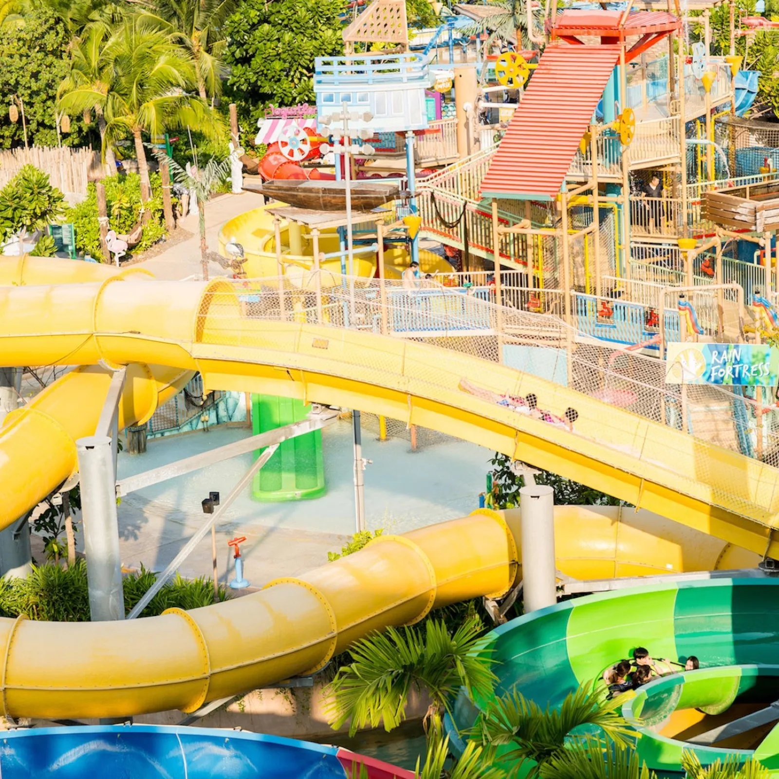 Yellow and green tube slides winding through the trees at Vana Nava Hua Hin