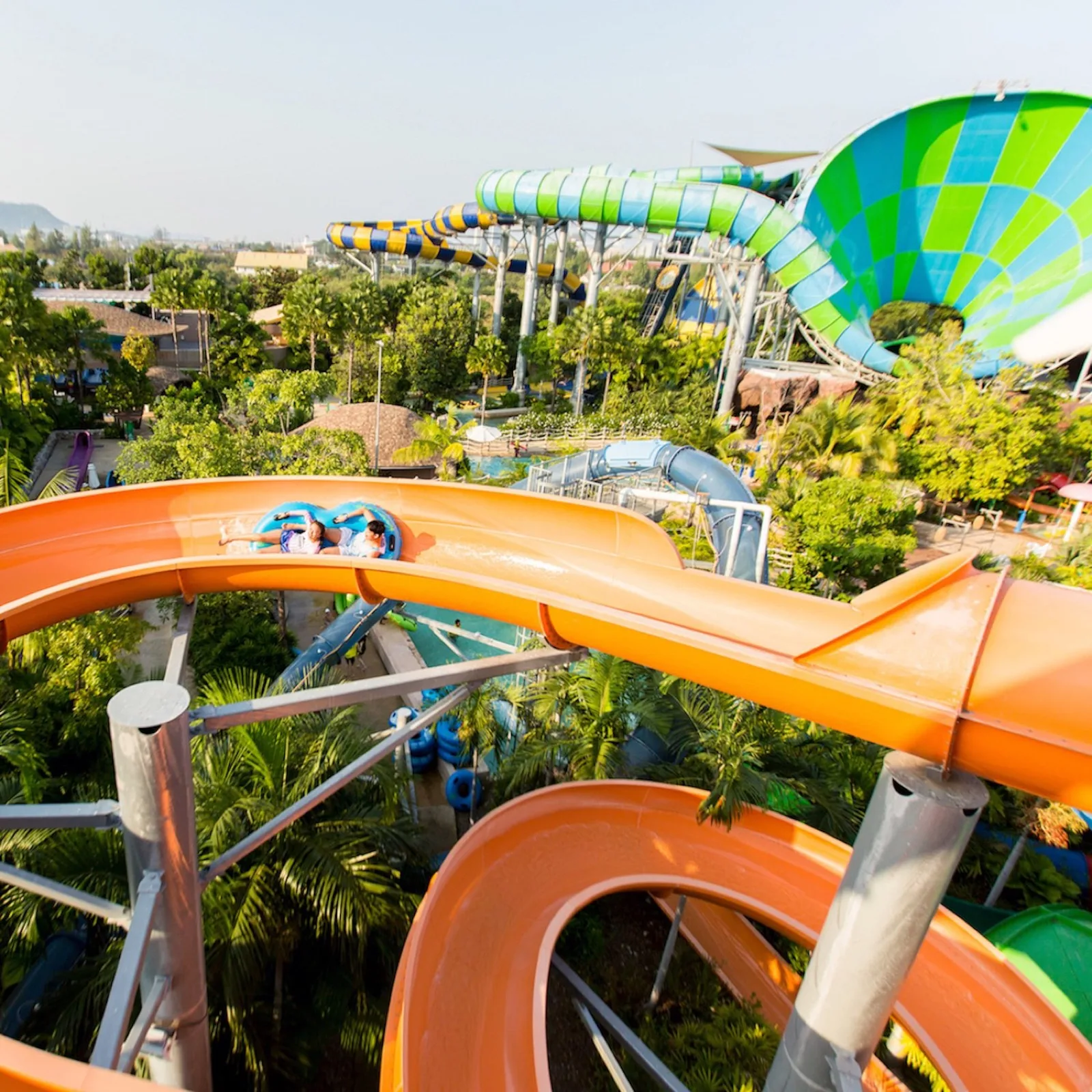 Orange tube slide with riders and the Abyss slide behind at Vana Nava Water Jungle