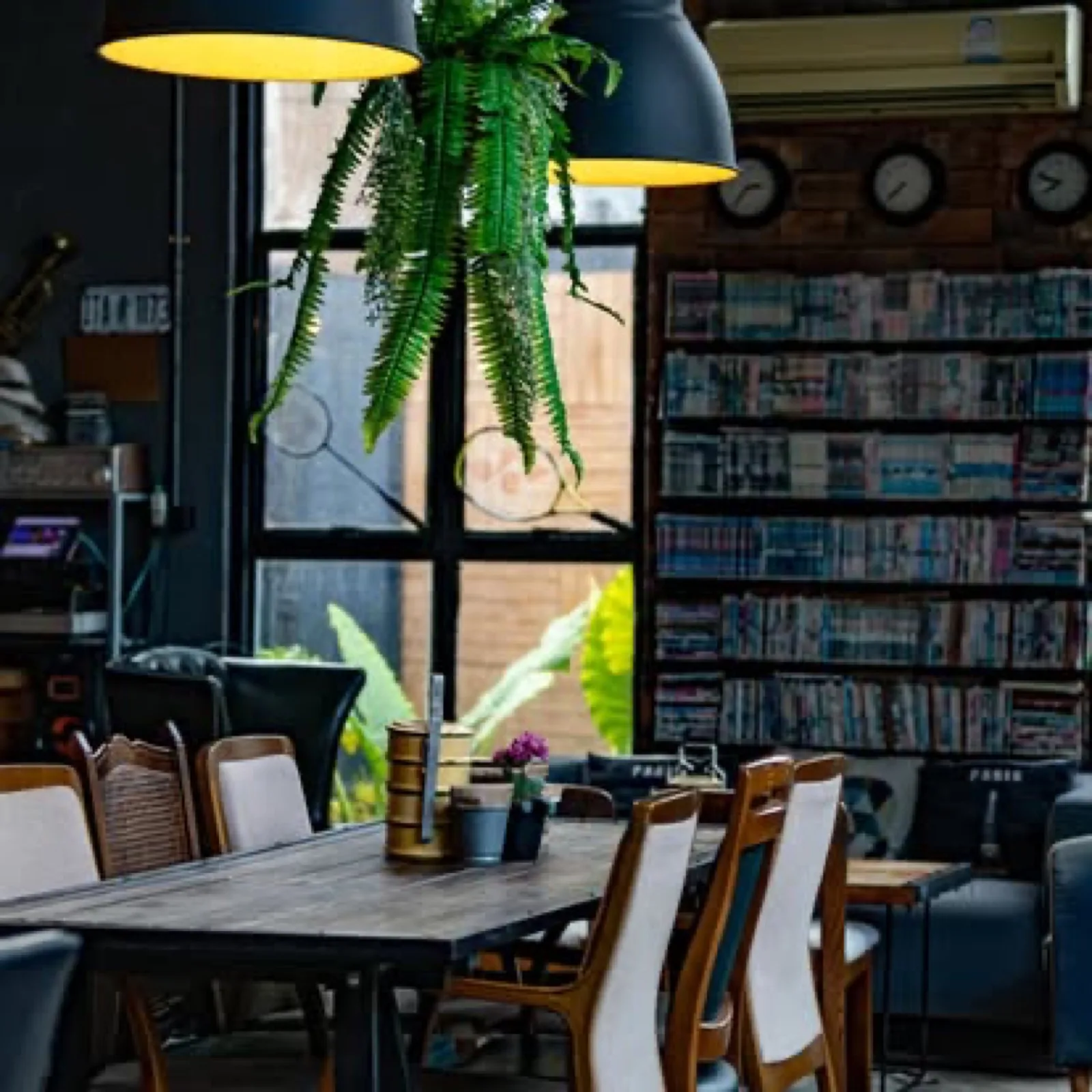 Warehouse-style cafe interior with bookshelves at Warehouse18, Don Sak