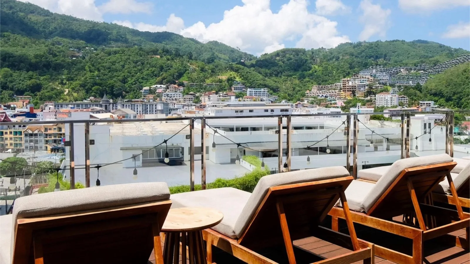 Rooftop sun loungers overlooking Patong town and hills at YouDee Hotel Patong